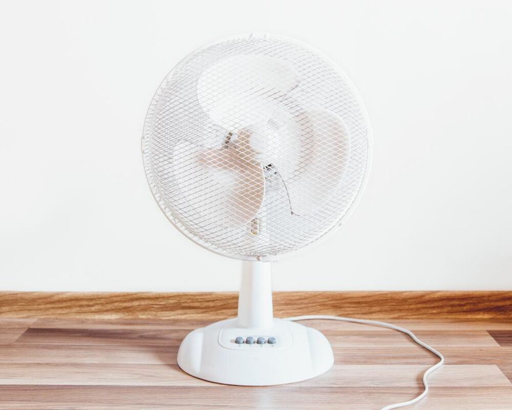 White table fan on a wooden floor