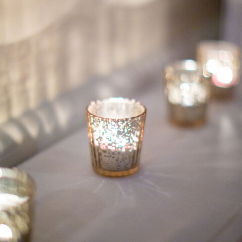 Glass votive candle holders glowing on a table